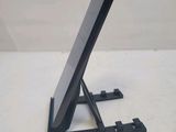 a black tablet on a stand on a white surface