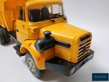 a yellow toy dump truck on a white surface