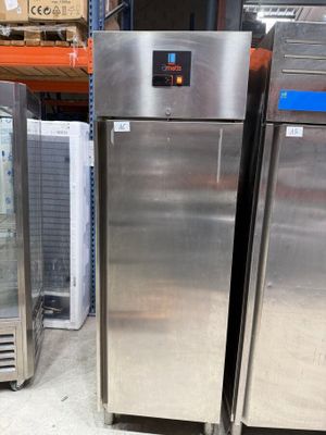 two stainless steel refrigerators in a store with glass doors