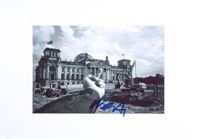 signed photograph of a hand pointing at a building under construction