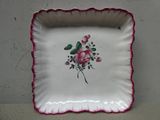 une assiette blanche ornée de fleurs roses posée sur une table