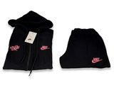 a pair of black sweatpants with pink nike logo on them