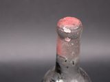 a glass bottle with a red cap sitting on a table