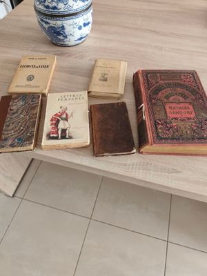 de nombreux livres sur la table et un vase sur la table
