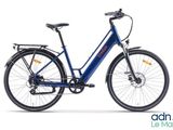 Le vélo électrique bleu est garé sur une surface blanche.