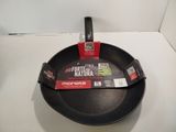a black frying pan with a red handle on a white counter
