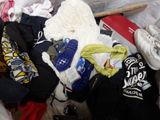 a pile of clothes and shoes on a bed
