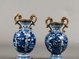 pair of blue and white vases sitting on top of a table
