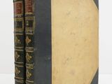 an old book sitting on top of a white table next to a white wall