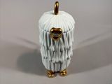 a white and gold figurine of a sheep with a gold nose