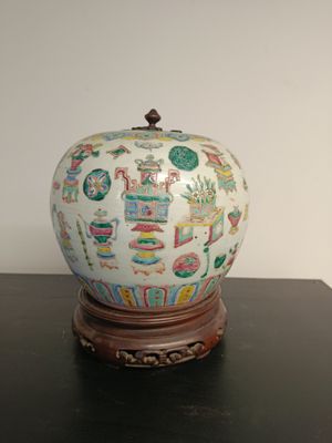 a white vase with colorful designs on it sitting on a table