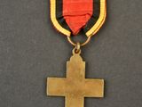a gold medal with a cross on it sitting on top of a table