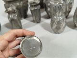 a person that is holding a silver object in front of a group of vases