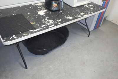 une photo d'une table sale sur laquelle se trouve une bouteille de bière