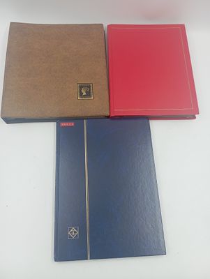 deux cahiers rouges et un cahier bleu posés sur une table blanche