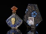 pair of glass perfume bottles sitting on top of a reflective surface