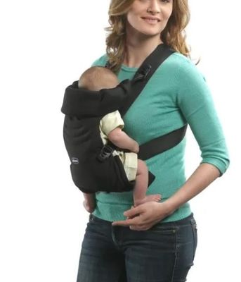 une femme tenant un bébé dans un porte-bébé