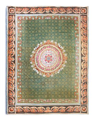 a green and orange rug with a circular design on it