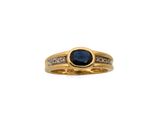 gros plan d'une bague en or avec un saphir et des diamants