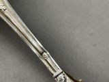 a close up of a silver spoon with a handle on a table