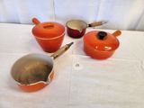 three pots and a pan on the table