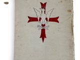 an old book with a red cross on it sitting on top of a table