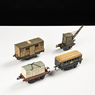 quatre wagons de train miniature sont alignés sur une surface blanche