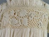 a close up of a white dress with crochets on it