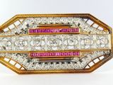 a close up of a gold and pink broochle with diamonds