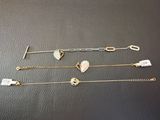 quatre bracelets différents ornés de breloques en forme de cœur, posés sur une table