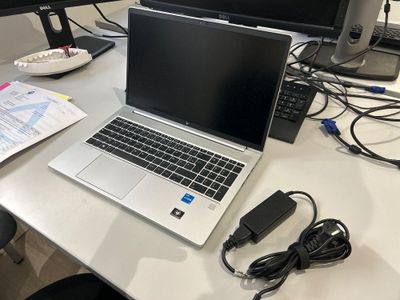 un ordinateur portable posé sur un bureau, à côté d'un écran