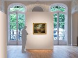 a sculpture in the middle of a room with a painting on the wall