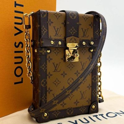 a louis vuitton handbag with a chain around it