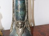 a blue vase sitting on a table next to a gold figurine