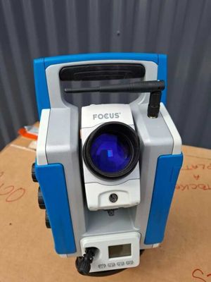 a close up of a blue and white camera on top of a cardboard box