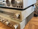 two silver stereo systems stacked on top of each other on a wooden floor