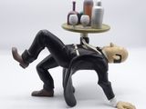 a figurine of a man laying on a table with bottles on it