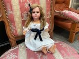a doll that is sitting on a chair in a room