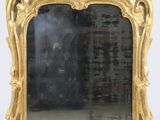un miroir avec un cadre doré posé sur une table blanche