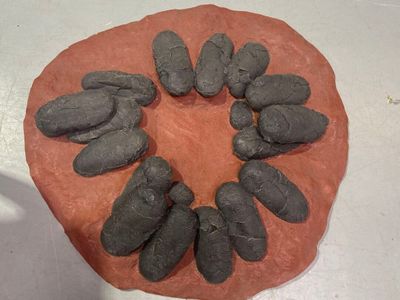 une sculpture en argile représentant un cercle formé de pierres posées sur une table