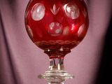 a red glass ball sitting on top of a wooden table