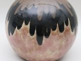a black and pink vase sitting on a white surface