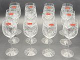 six clear wine glasses are lined up in a row