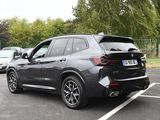 the bmw x5 is parked in a parking lot with other cars