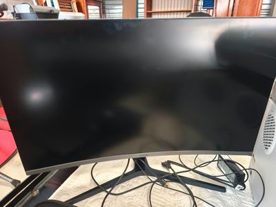 un écran d'ordinateur posé sur une table, à côté d'un clavier