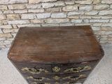 a small wooden chest of drawers on the floor