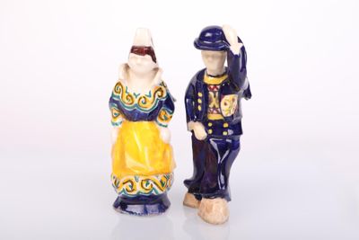 two figurines of a man and a woman standing next to each other