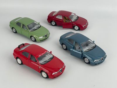 four toy cars sitting in a row on a white surface