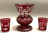 un vase rouge et deux verres posés l'un à côté de l'autre