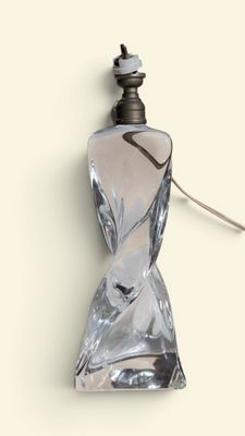 une image représentant un flacon de parfum posé sur une surface blanche